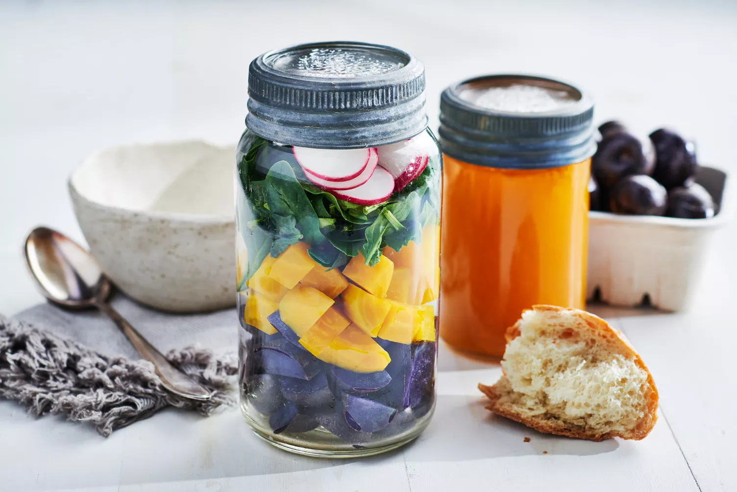 Mason jars with stacked colorful veggies ready to make a tasty soup.