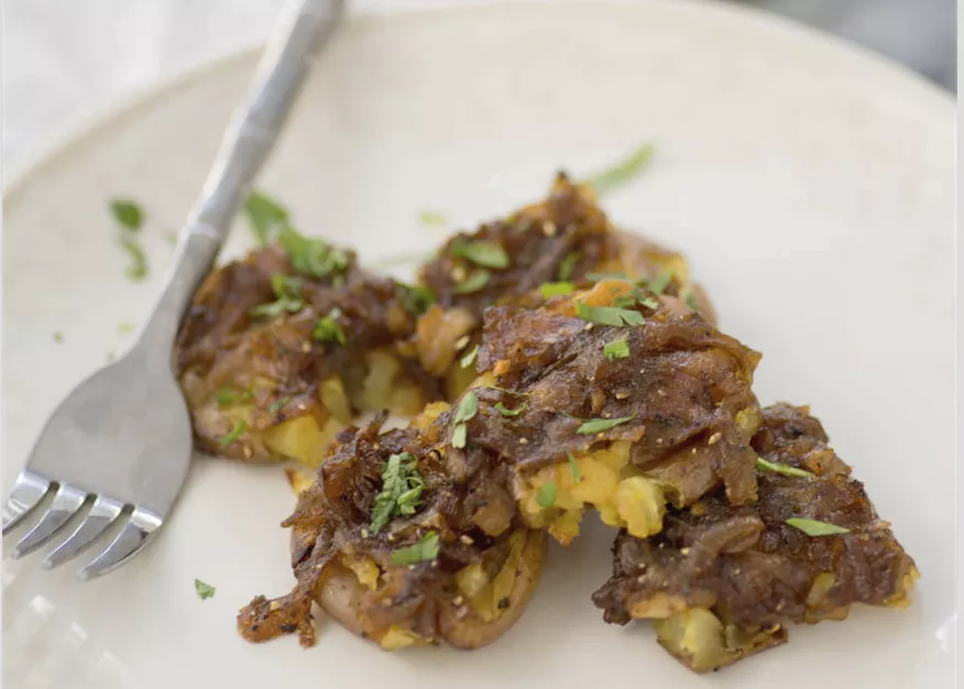 Petites pommes de terre écrasées avec des échalotes en sauce